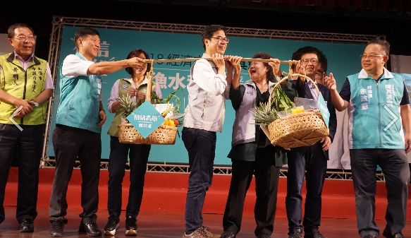 民進黨高雄市長候選人陳其邁將象徵高雄的「菜擔子」一肩扛起。   圖：陳其邁選辦提供