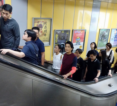 香港影星「發哥」周潤發（紅衣者）為宣傳新片「無雙 」訪台，7日下午搭乘捷運前往南港，沿途與民眾互動、自拍，展現十足親和力。   圖：中央社 （雙喜電影提供）