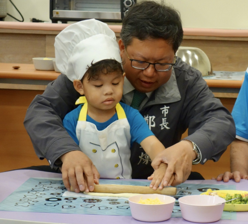 鄭文燦和小朋友一起在全新打造的「親子廚房」區DIY做披薩。   圖：桃園市政府／提供