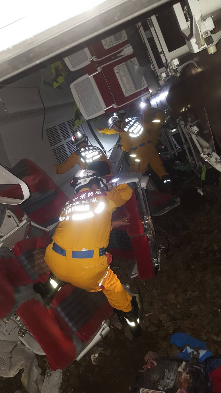 基隆市消防隊搶救人員在翻覆的普悠瑪列車中搜尋旅客。   圖 : 基隆市消防局/提供