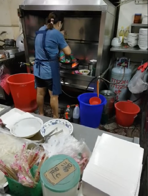 有網友在臉書社團「爆料公社」PO出影片，一名羊肉店女員工將用尼龍袋裝著的米粉直接放入鍋子烹煮，並用鍋鏟將整袋米粉壓入。   圖：翻攝自爆料公社