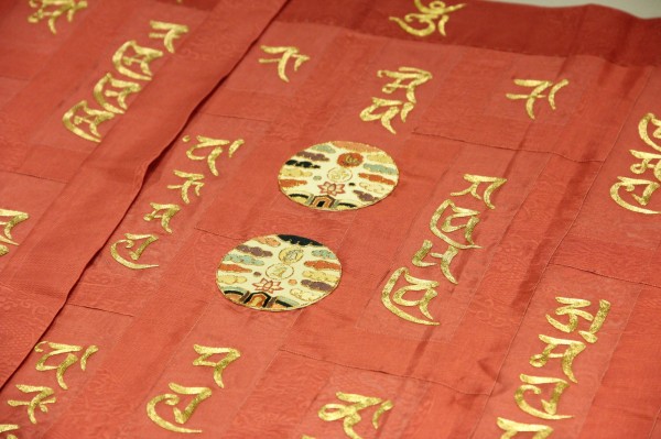 梵語日月光紋25條繡袈裟，以平繡單套與盤金針法繡出日月光紋和金色梵文。   圖：世界宗教博物館／提供