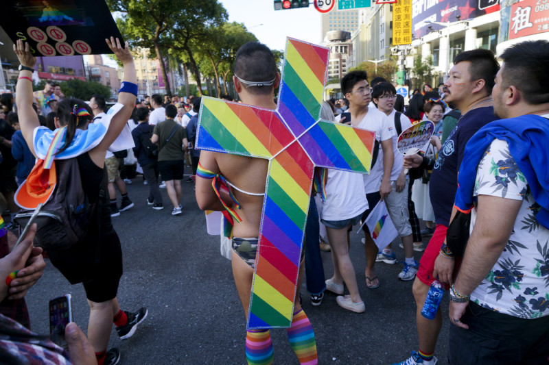 一位男同志背著彩虹十字架參加同志大遊行。   圖：張良一/攝