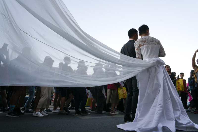 兩位男同志穿著婚紗走上台北街頭，希望同性婚姻能盡快落實。   圖：張良一/攝