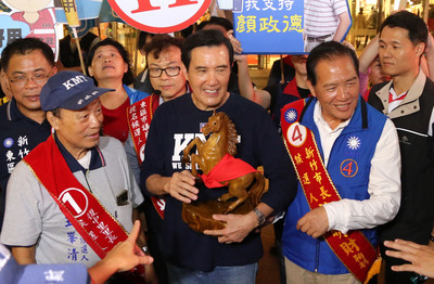 前總統馬英九（前中）4日晚間陪同國民黨新竹市長參選人許明財（前右）掃街拜票，並贈送一座木雕馬給許明財，祝他這次選舉「馬到成功」。   圖：中央社