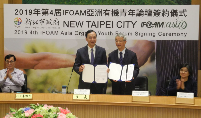 朱立倫今早與國際有機農業聯盟亞洲分部主席周澤江 (立者右)簽約，敲定明年在新北市舉辦「2019 IFOAM Asia有機青年論壇」。 
   圖：王峻昌/攝