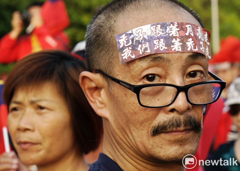 有支持者把韓國瑜的金句「跟著禿子走」貼在額頭上，表達支持的熱情。   圖：張良一／攝
