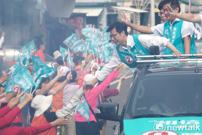 陳其邁站在宣傳車上握起路旁支持者的手。   圖：張良一/攝