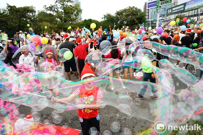 高雄WeCare氣球大遊行，現場孩童玩起泡泡。   圖：張良一／攝