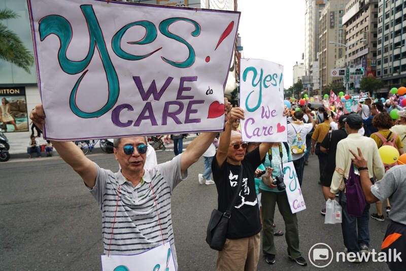 高雄WeCare氣球大遊行，現場民眾高舉Yes We Care標語。   圖：張良一／攝