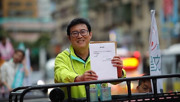 民進黨台北市長候選人姚文智今（19）天下午在中正、萬華區掃街時，展示他已簽署立委辭職書。   圖：姚文智競選辦公室提供