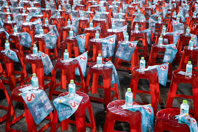 民進黨高雄市長候選人陳其邁林園造勢晚會的椅子上放置陳其邁競選旗幟和瓶裝水。   圖：張良一/攝