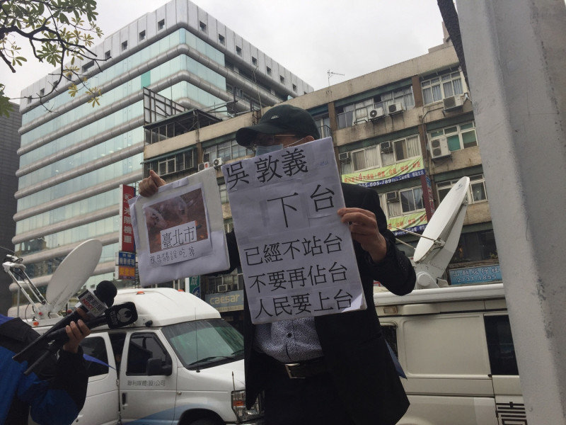 中常會召開前，有民眾手持「吳敦義下台、韓國瑜上台」告示牌抗議。   圖：趙婉淳／攝