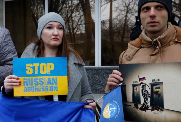 烏克蘭民眾舉標語抗議俄羅斯的侵略行動。   圖：達志影像/路透社