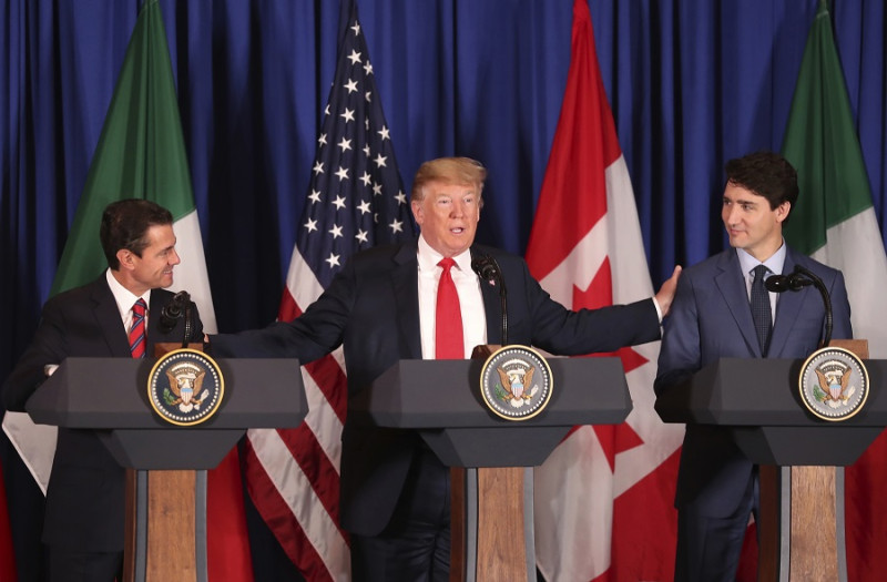美國總統川普（中）與加拿大總理杜魯道（右）、墨西哥總統潘尼亞尼托（左）簽署新的自由貿易協定。   圖：達志影像/美聯社
