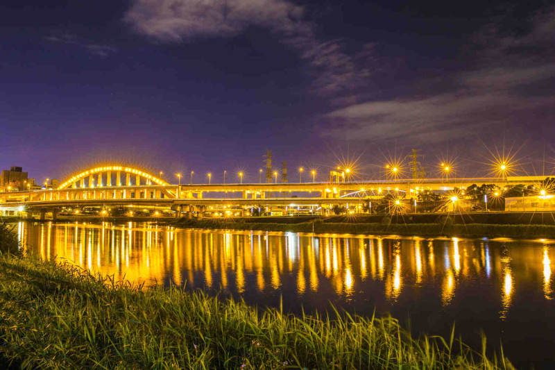 騎基隆河自行車道，可以看到金光閃閃的麥帥一橋。   圖：台北市政府工務局水利工程處／提供