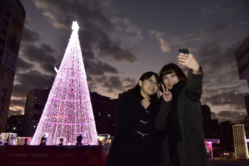桃園市府前廣場的「幸福天光」LED耶誕樹搭配每半小時一次的燈光秀，吸引不少民眾前來拍照，感受「幸福天光」。   圖：桃園市政府/提供