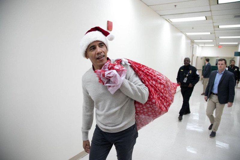 美國前總統歐巴馬（前）在耶誕節前夕，扮成耶誕老人造訪華盛頓兒童醫院，分送禮物。   圖：翻攝YouTube/NBC News