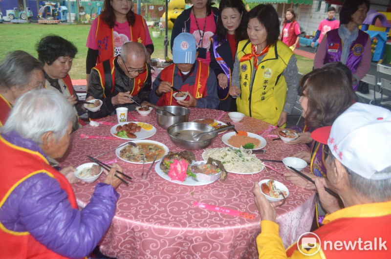 華山基金會等單位今天提前為部份獨居老人辦桌，享用年菜。   圖：蔡坤龍/攝