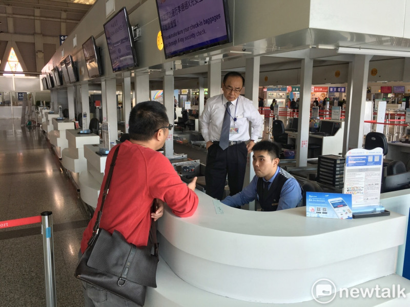 搭乘華航旅客在華航高雄小港國際機場辦理改機票手續。   圖：張良一攝