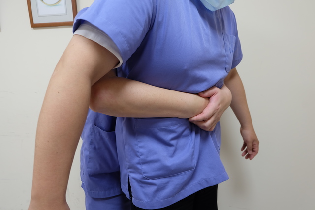 哈姆立克法施作方式為站在患者後方，環抱後多次往上腹部按壓，藉此將梗塞食物彈出。   圖：羅東博愛醫院/提供