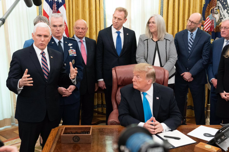 美國總統川普（中坐者）19日簽署《第4號太空政策令》，副總統彭斯（左）解釋成立太空部隊的迫切性。   圖：翻攝自彭斯推特
