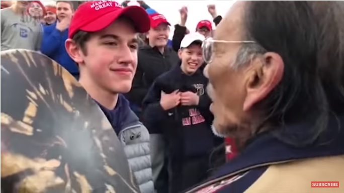 美國肯塔基州高中生桑德曼(左)疑似嘲弄一名原住民老兵(右)事件，他聲稱《華郵》不實指控他做出種族歧視行為，今天決定提告。   圖：翻攝Youtube