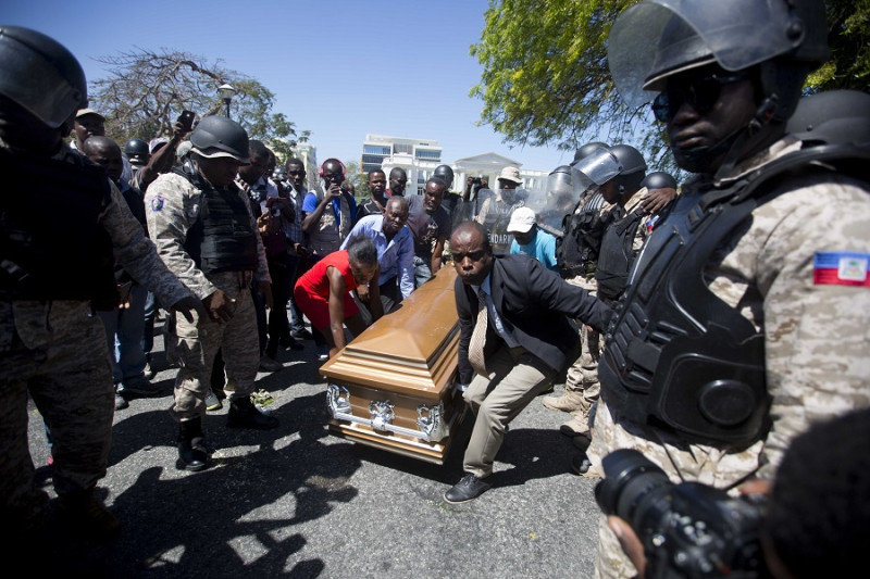 海地民眾22日抬著在上週不幸喪命示威者棺材，要求總統摩依士下台。   圖：達志影像/美聯社