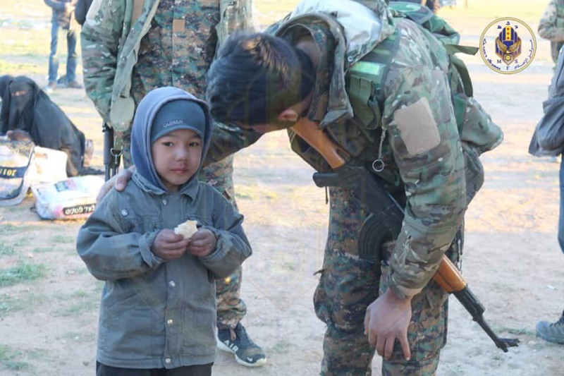 敍利亞軍事委員會發布照片，軍方在伊斯蘭國最後據點巴古茲清理戰場，圖為士兵在安撫倖存的小朋友。   圖：翻攝自敍利亞軍事委員會推特
