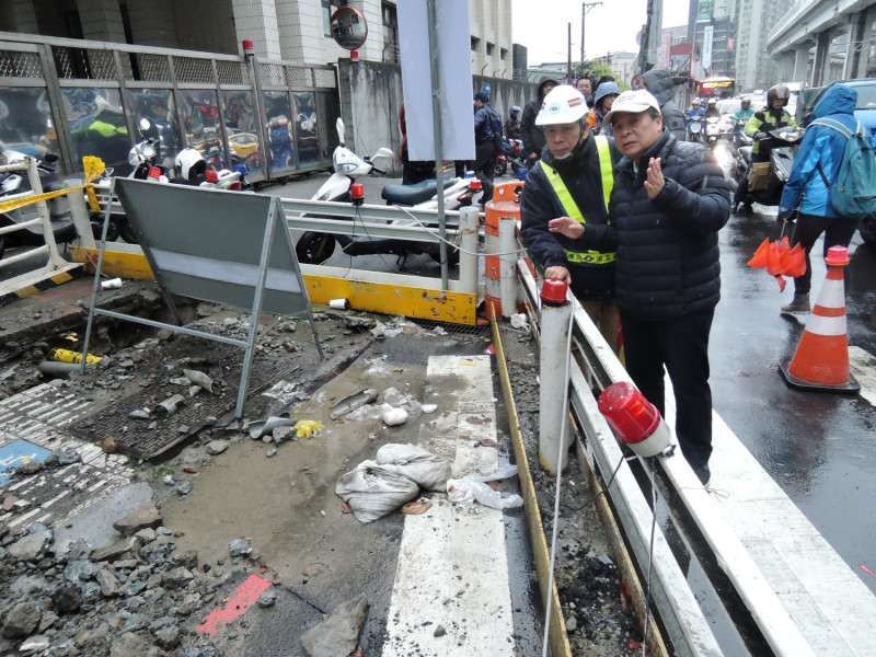 新北市交通局長鍾鳴時(右)突擊景平路、秀朗路口的人行道及地下排水箱涵工程工地，要求施工單位內縮工程圍籬，還路於民。   圖／新北市交通局提供