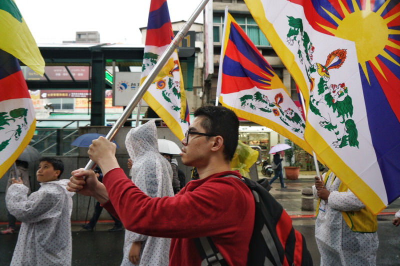 310西藏抗暴日60週年遊行，支持者不畏風雨，高舉西藏國旗隨著隊伍前行。   圖：張良一/攝
