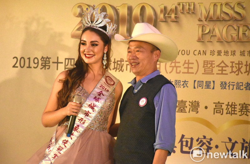 韓國瑜(右)戴上去年城市小姐世界盃冠軍贈送的牛仔帽。   圖：孫家銘／攝