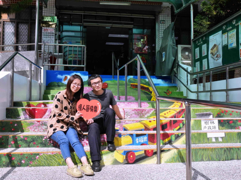 樹林戶政所打造「搭乘戶政幸福列車」拍照專區，將門口階梯化身為心心相印的3D火車站彩繪地景，寓意新人搭乘幸福號列車「幸福一生」。    圖：新北市民政局提供