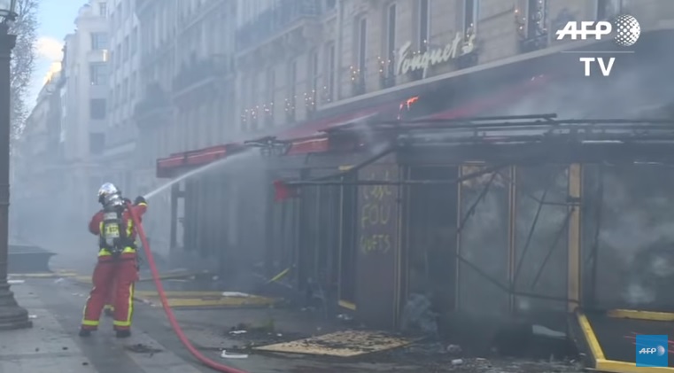 巴黎香榭麗舍大道餐廳、商家、書報亭遭嚴重焚燒及毀損。   圖：翻攝Youtube