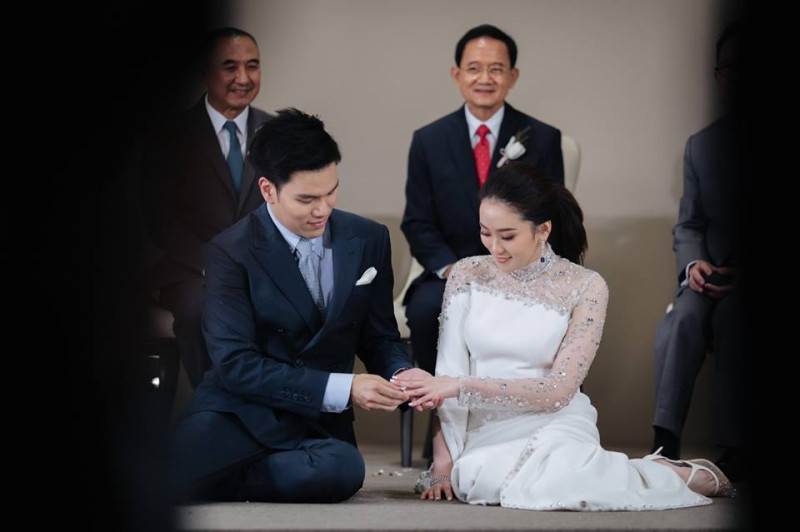 泰國前總理盈拉在臉書上po出哥哥戴克辛（後排右）看著幼女貝東丹（前排右）與女婿機師彼多互換戒指的照片。   圖：翻攝自盈拉臉書
