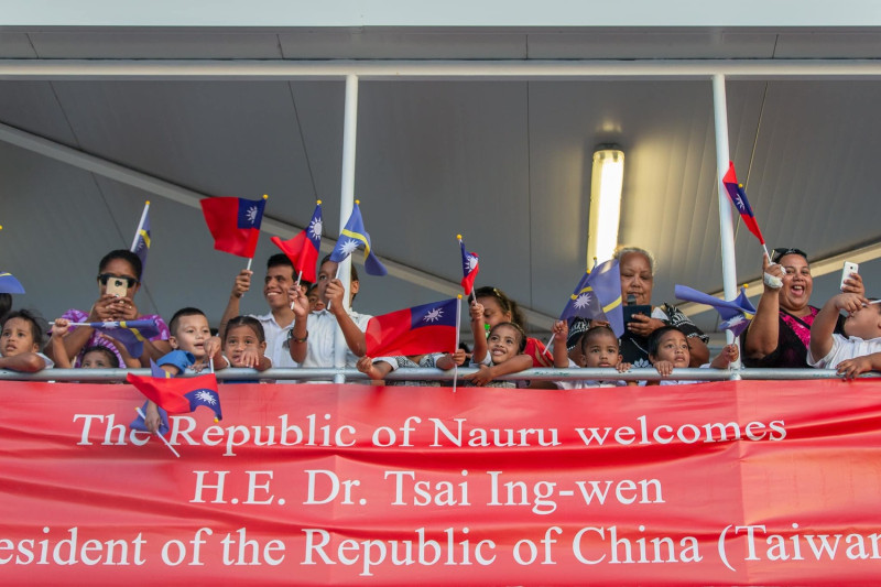 諾魯當地聚集民眾揮舞兩國國旗，歡迎蔡英文的來臨。   圖:翻攝自蔡英文臉書。