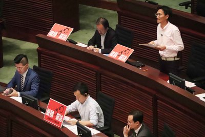 香港立法會3日稍後將會首讀香港逃犯（修訂）條例草案，泛民強烈反對修法；圖為行政長官早上接受議員質詢時，泛民議員在席上擺放「撤回惡法」標語。   圖：中央社