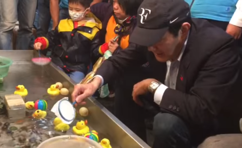 前總統馬英九在兒童節玩撈魚遊戲。   圖：翻攝自馬英九臉書