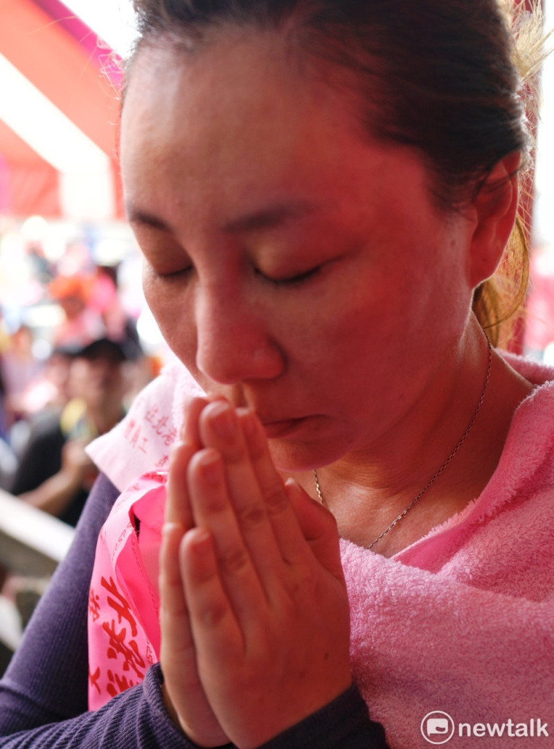 一位白沙屯媽祖的信眾雙手合十向媽祖祈禱。   圖：張良一/攝