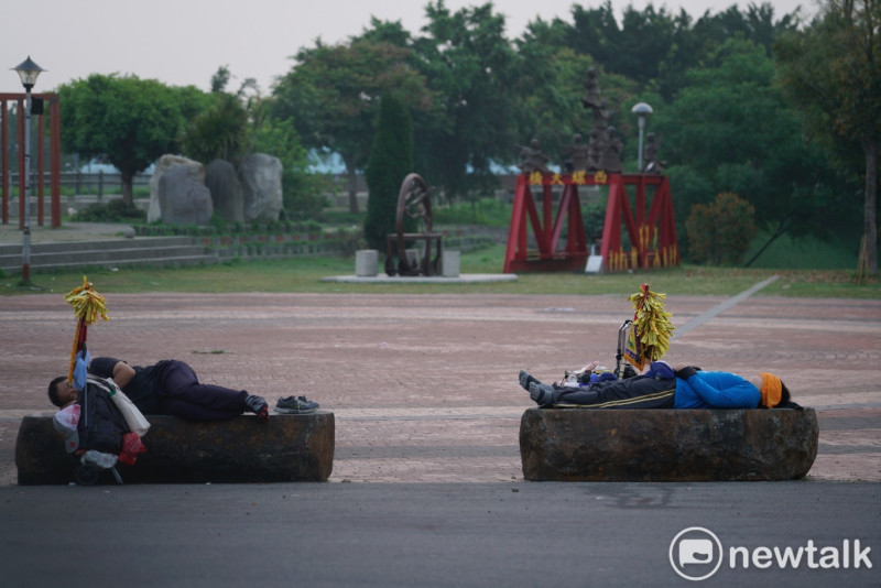 兩位大甲媽祖的信眾清晨時分在西螺大橋橋頭附近露天睡覺。   圖：張良一/攝