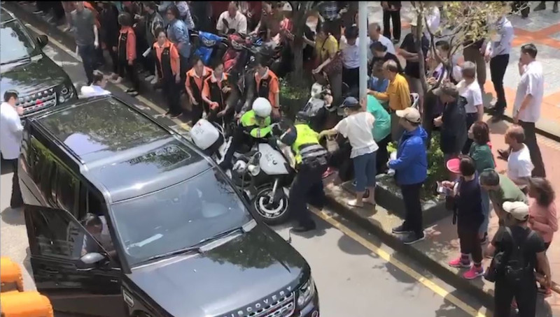 總統蔡英文今(5)天上午參訪新北市板橋區潮和宮，孰料隨行隨扈開門下車時，不慎撞倒一旁騎機車的員警，員警接連撞傷在路旁的圍觀70歲老婦。   圖：翻攝自Youtube