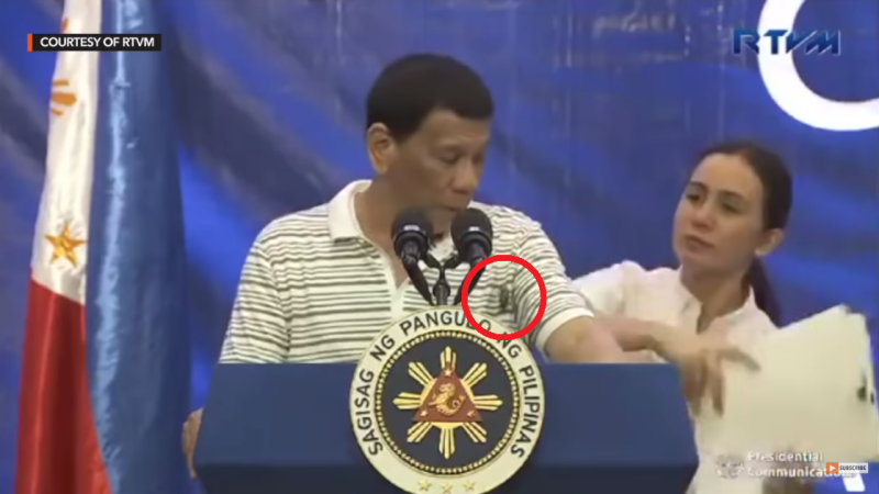 菲律賓總統杜特蒂8日公開演說時，一隻超大蟑螂竟然爬上胸口，杜特蒂開玩笑地說，「這是反對黨派來的。」   圖：翻攝自YouTube