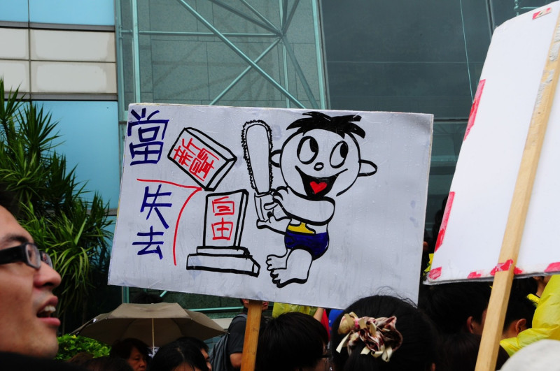 遊行中有民眾高舉「新聞自由」遭剝奪的示牌，強調旺中集團併購案的後患。