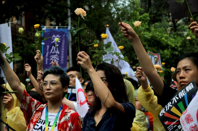 挺同活動現場群眾舉起玫瑰花為逝去的生命哀悼。   圖：婚姻平權大平台提供