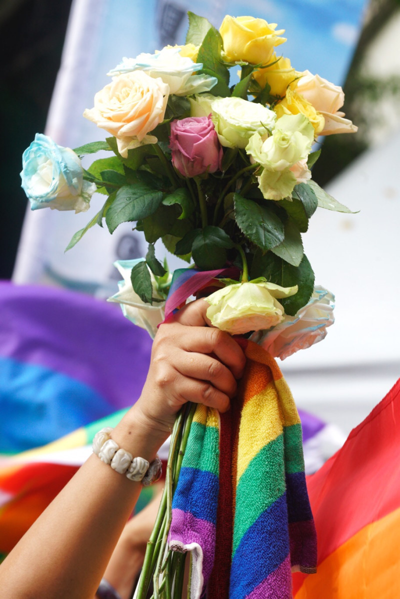 支持同婚專法民眾，以「彩虹」巾包裹一束玫瑰，象徵愛「無界限」。   圖：張良一 / 攝