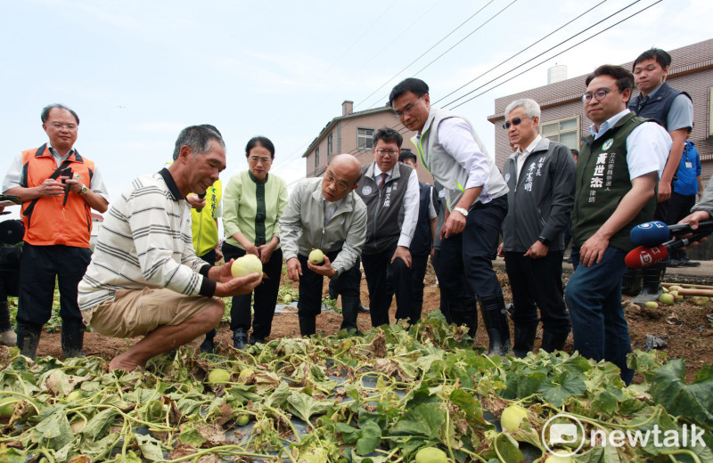瓜農拿著泡爛的香瓜向行政院長蘇貞昌說明原本再過三天就可以採收的香瓜，這下子因為暴雨，全部泡爛無法採收。   圖：林昀真／攝