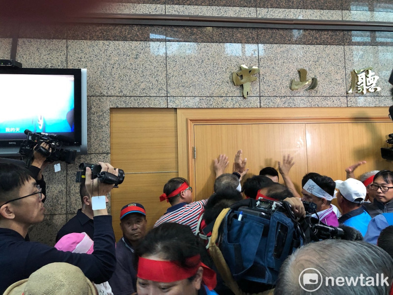 陳抗民眾直接衝入中央黨部一樓，聚集在召開中常會的中山廳前，並輪流5人一組捶門要闖入，要求和主席吳敦義直接對話。   圖：謝莉慧/攝