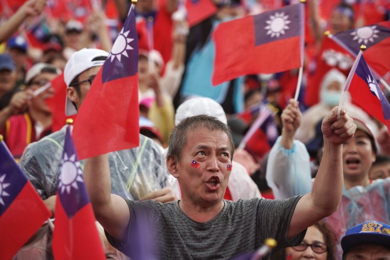 國旗元素在今天的挺韓造勢大會為主軸，圖中的支持者不僅手拿國旗，雙頰還貼上迷你國旗貼紙一同跟著主持人吶喊。   圖：張良一 / 攝