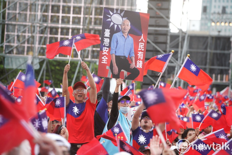 韓粉自製印有韓國瑜照片和「人民有錢、台灣安全」看板，揮舞吶喊。   圖：張良一 / 攝(資料照片)