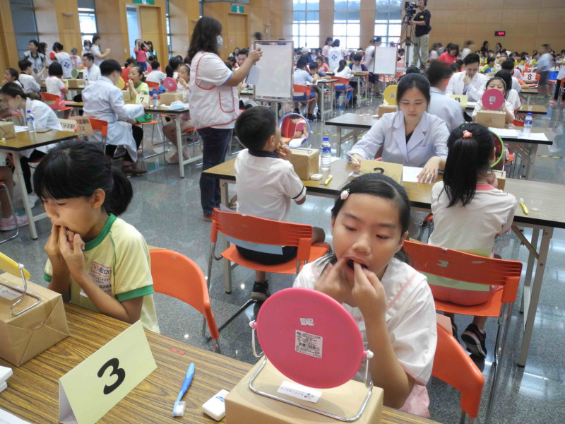 新北市小學潔牙比賽，小朋友當場以牙線、牙刷潔牙，由牙醫師評分。    圖：王峻昌／攝